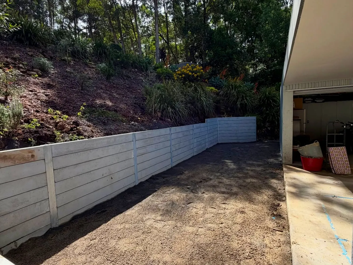 After — finished concrete sleeper retaining wall opening a flat usable space (Doonan)